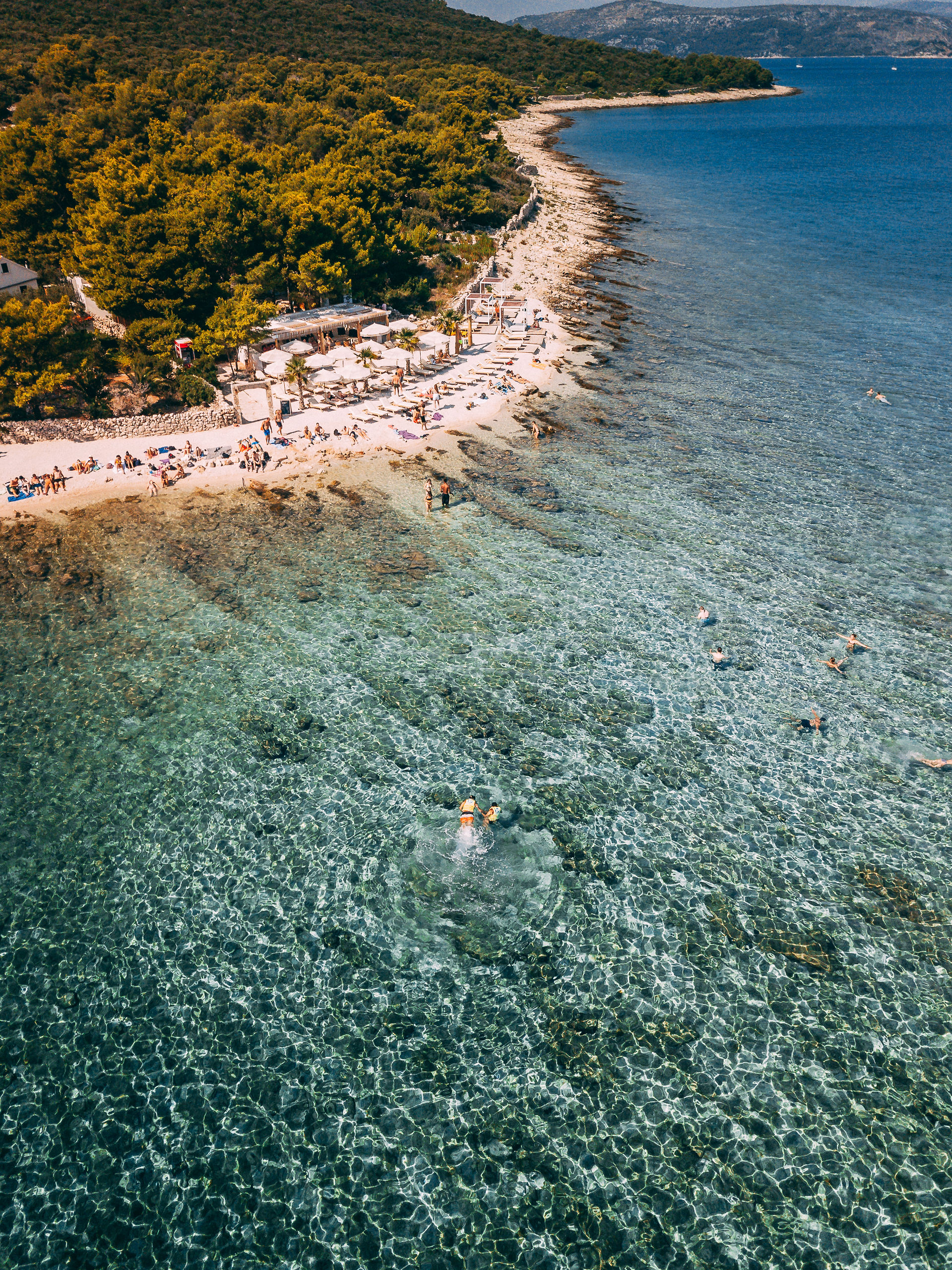 Aerial view of Blue Lagoon Croatia with crystal clear turquoise water and swimmers on the beach