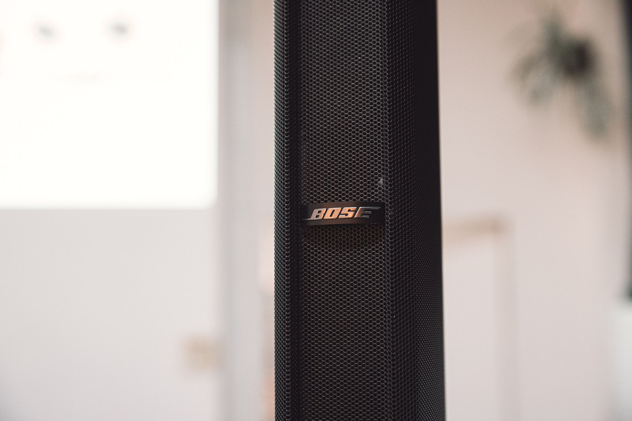 Bose F1 speaker close-up showing logo and mesh grille detail