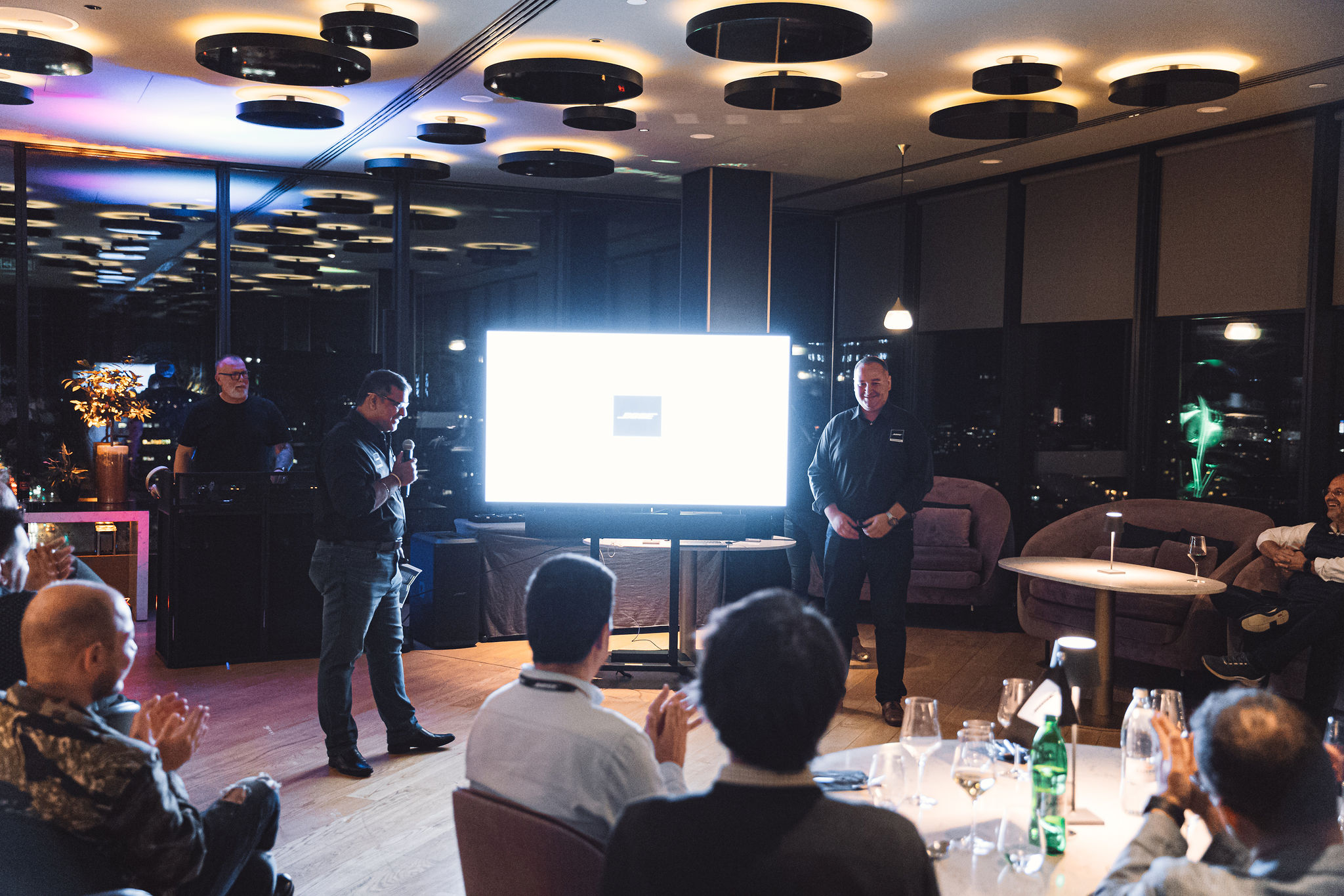 Corporate presentation with audience applause and DJ booth setup