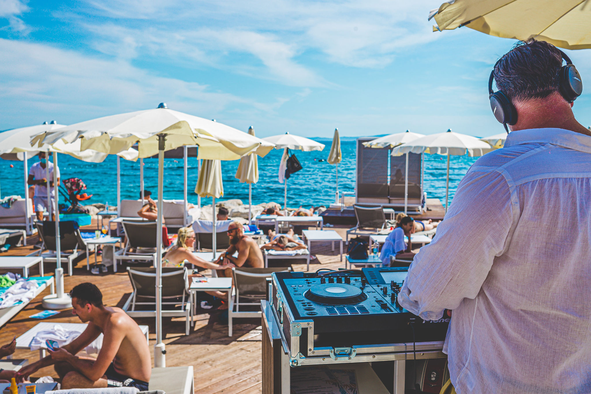 DJ nastupa za mixetom s pogledom na publiku na plaži — Mistral Beach Club