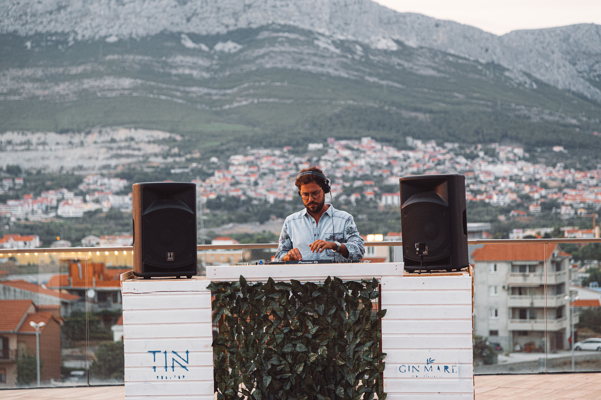 DJ booth at TIN rooftop with Gin Mare branding and Split mountain panorama behind
