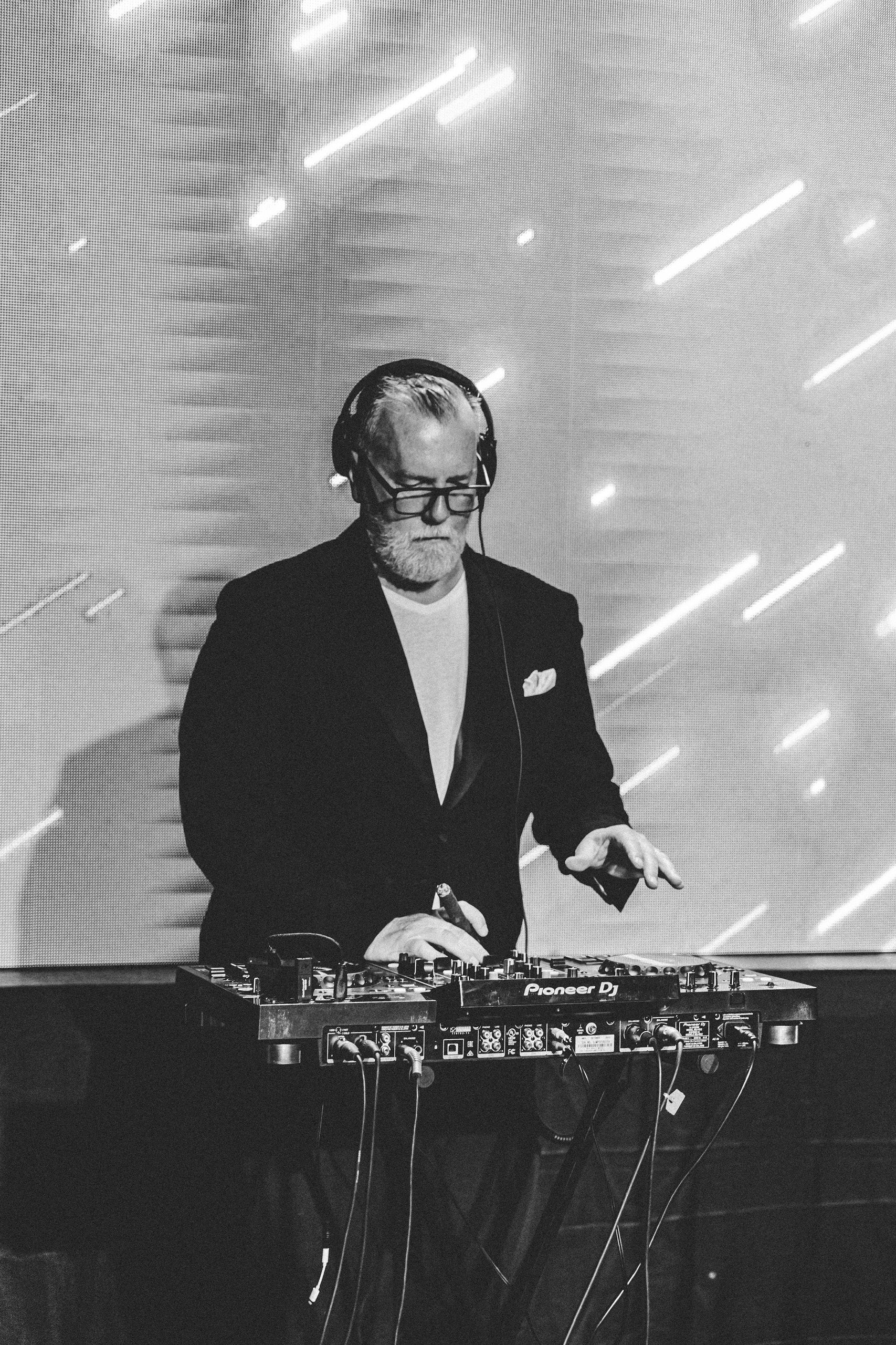 DJ Matthew Bee performing at Pioneer DJ setup during corporate fashion show event in Split