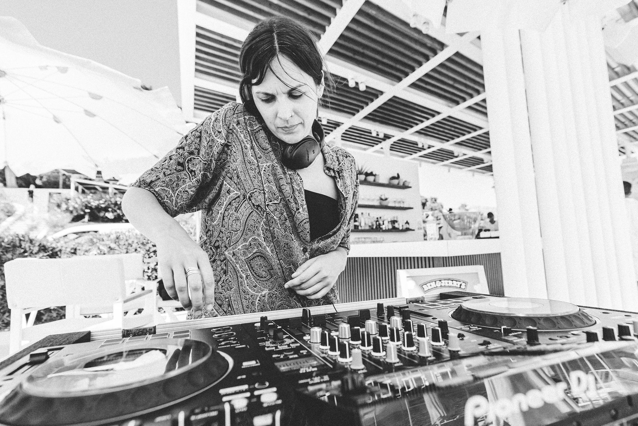DJ Niki Peducci mixing on Pioneer DJ at a beach club — Cosmic Production DJ roster diversity