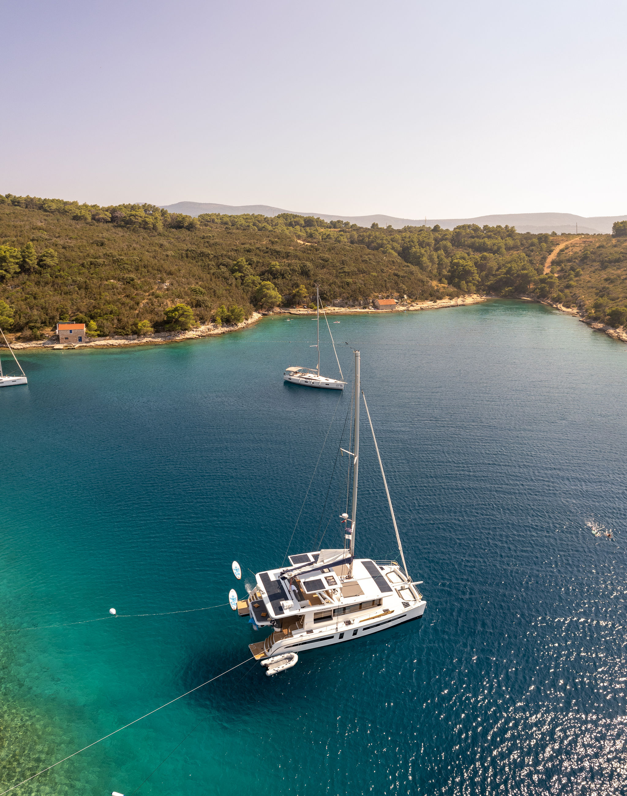 Catamaran in a turquoise Adriatic cove — island event logistics in Croatia