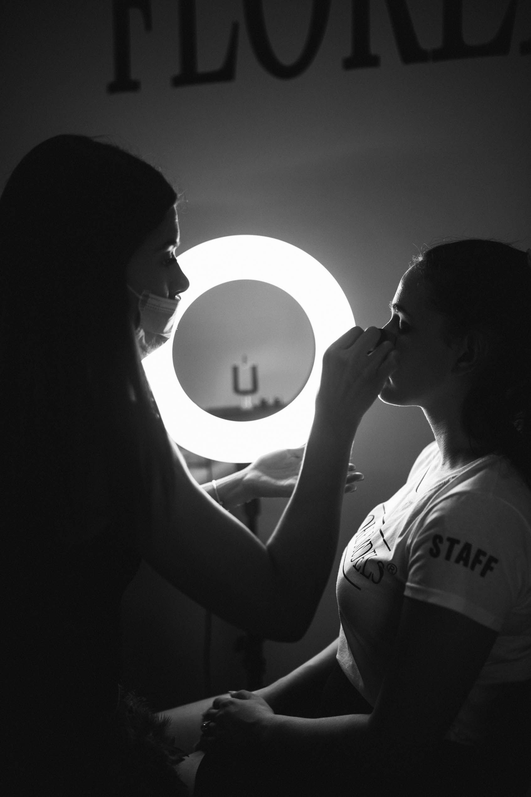 Backstage fashion show makeup photography in dramatic black and white