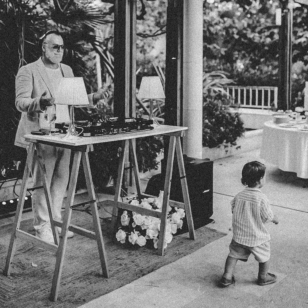 DJs For Weddings in Croatia - Cosmic Production DJ Agency and AV Company DJs For Weddings in Croatia - Cosmic Production DJ Agency and AV Company. Image features a DJ playing on a chich premium wedding event in Split, Croatia. With his table full of DJ equipment with a small child passing by in a relaxed dinner atmosphere at Hotel Park in Split